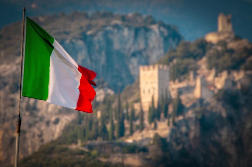 Bandiera Italiana con sullo sfondo il Castello di Arco (Tn)